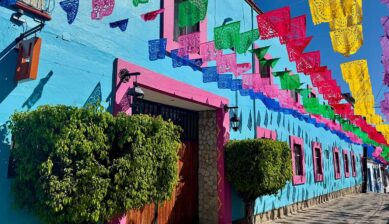 メキシコのカラフルな街並みに飾られたパペルピカドの装飾