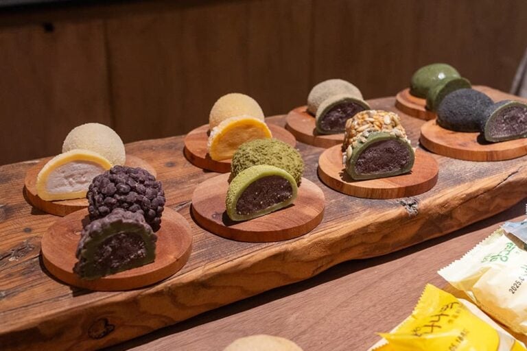 木製の台に並べられた、あんやクリーム入りの色とりどりの韓国餅スイーツ