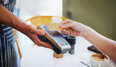 カフェの決済端末にクレジットカードをかざして支払う様子