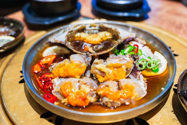 醤油だれに漬けた生のカニを切り分け、唐辛子を添えた韓国料理のカンジャンケジャン