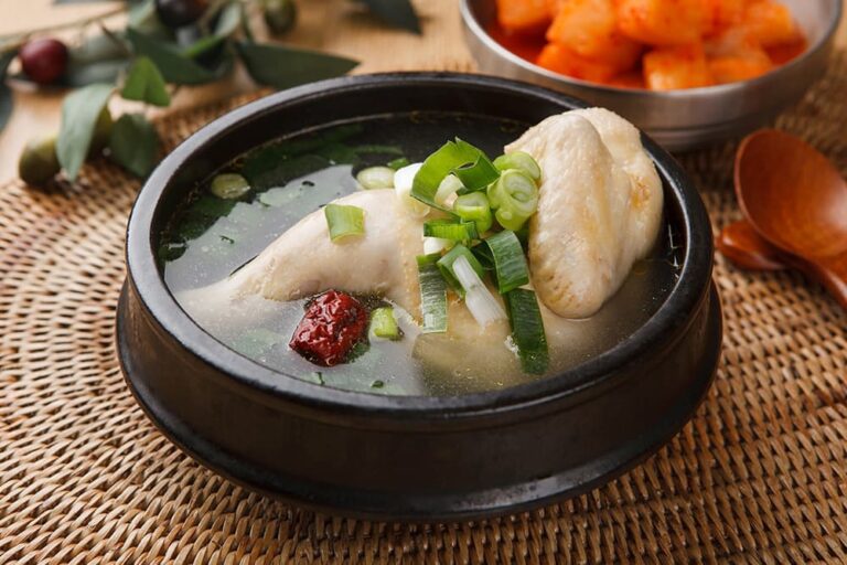 黒い土鍋で丸鶏とナツメ、ねぎを煮込んだ韓国料理の参鶏湯