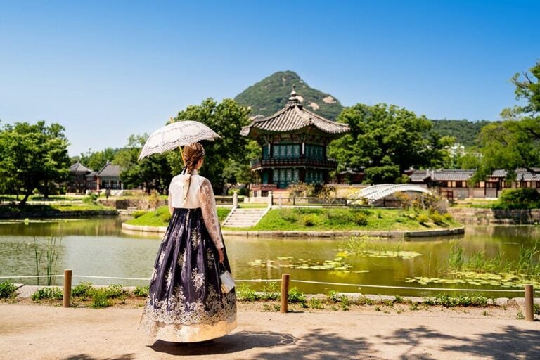 ソウルの景福宮で韓服を着て香遠亭を眺める女性