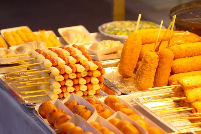 餅とソーセージの串や揚げ物、餃子などが並ぶ韓国の屋台グルメ