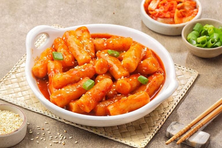 細長い餅を赤いコチュジャンソースで煮込み、ごまやねぎを添えた韓国のトッポッキ
