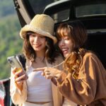 旅行先でスマートフォンを見る2人の旅行者