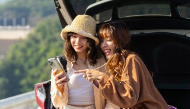 旅行先でスマートフォンを見る2人の旅行者