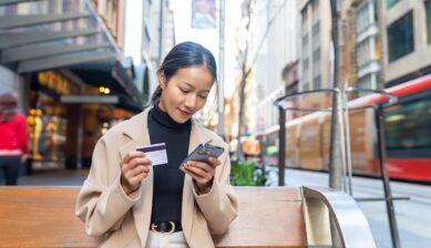 海外旅行中にスマートフォンでeSIM料金を確認する女性