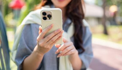 10ギガのデータ通信量でどれくらいスマホが使えるかを解説する、屋外でスマートフォンを操作する女性のアイキャッチ画像