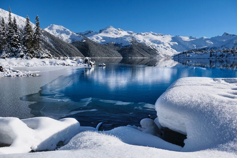 ウィスラーの雪に覆われた山々と静かな湖が広がる冬の風景