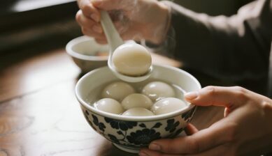 記事「上海グルメおすすめ10選」のアイキャッチ画像。花柄のお椀に入った温かい名物スイーツ「湯圓（タンユエン）」をレンゲですくい上げる様子