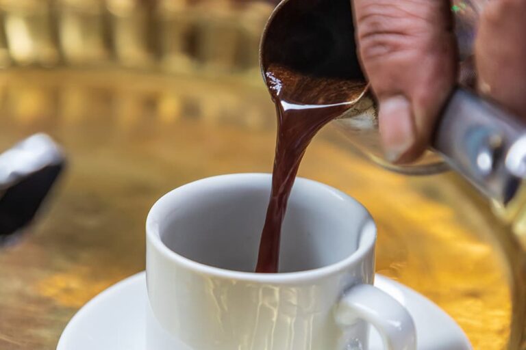 エジプトの代表的な飲み物である、専用の小鍋から白いカップへと注がれる濃いめのアラビックコーヒーの様子