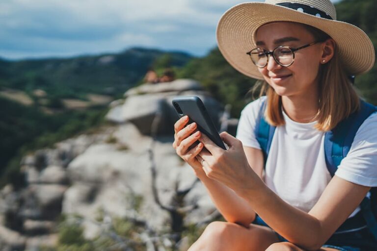 海外旅行先で10ギガのデータ通信を利用しながらスマートフォンを操作する旅行者の様子