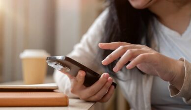 カフェのテーブルでスマートフォンを操作する女性