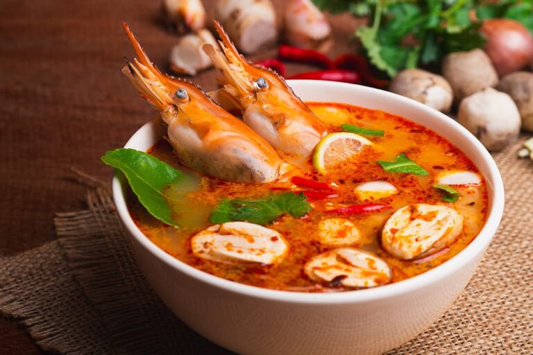 大きなエビやマッシュルームが目を引く、タイの代表的な食べ物「トムヤムクン」。辛味と酸味が特徴の赤い定番スープが器にたっぷりと盛られた様子