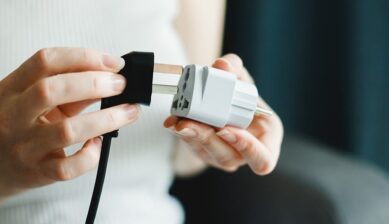 白い変換プラグに電源プラグを差し込もうとする手元