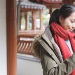 旅行先の屋外でスマートフォンを操作する女性