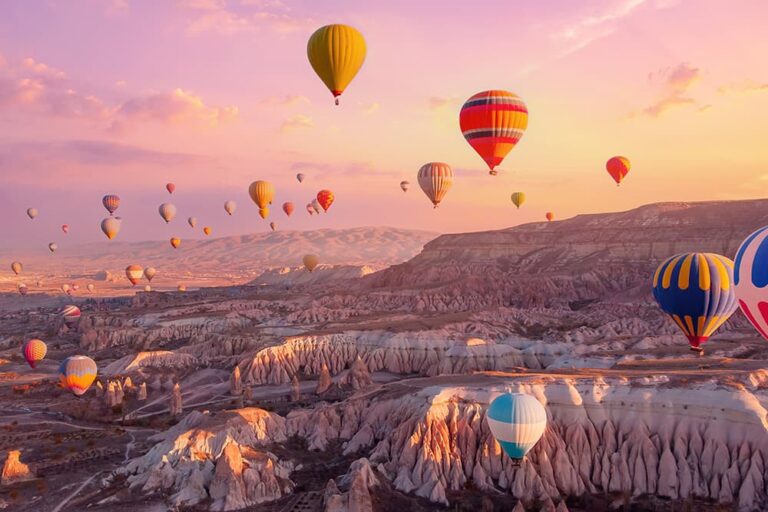 ヨーロッパ方面で物価が安く旅行しやすい国として人気のトルコを代表する絶景、朝焼けの空に無数の熱気球が浮かぶカッパドキアの奇岩地帯の風景