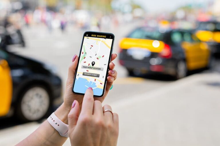 街中でスマートフォンの配車アプリを使い、タクシーを手配している手元