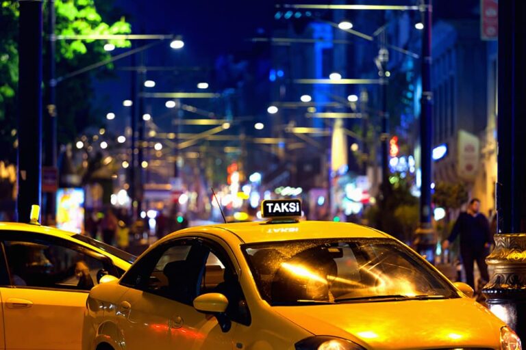 街灯が輝く夜のイスタンブールの街を走る黄色いタクシー