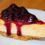 ニューヨークの定番名物グルメ・スイーツとして紹介する、ブルーベリーソースがかかった濃厚なチーズケーキ