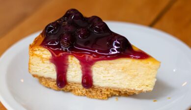 ニューヨークの定番名物グルメ・スイーツとして紹介する、ブルーベリーソースがかかった濃厚なチーズケーキ