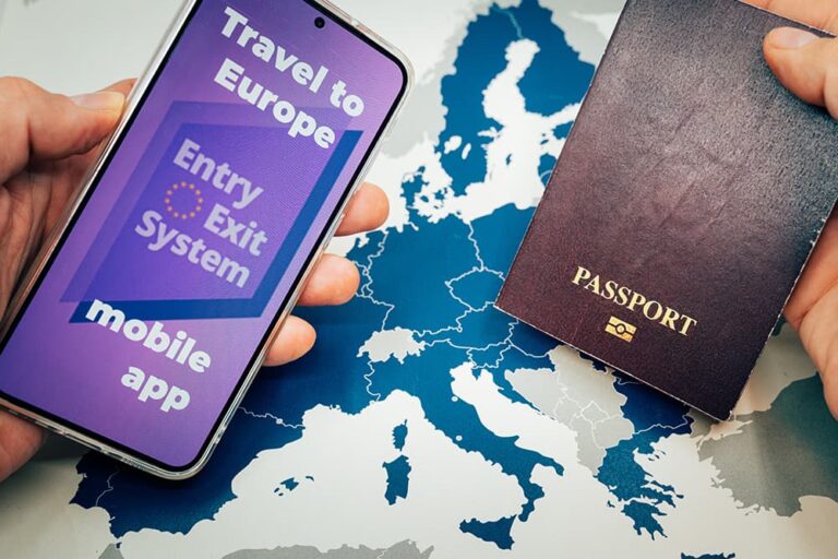 ヨーロッパ地図を背景に、EES（欧州出入国システム）のモバイルアプリ画面を表示したスマートフォンとパスポートを手に持つ様子。欧州渡航前の事前申請や準備手続きをイメージした画像