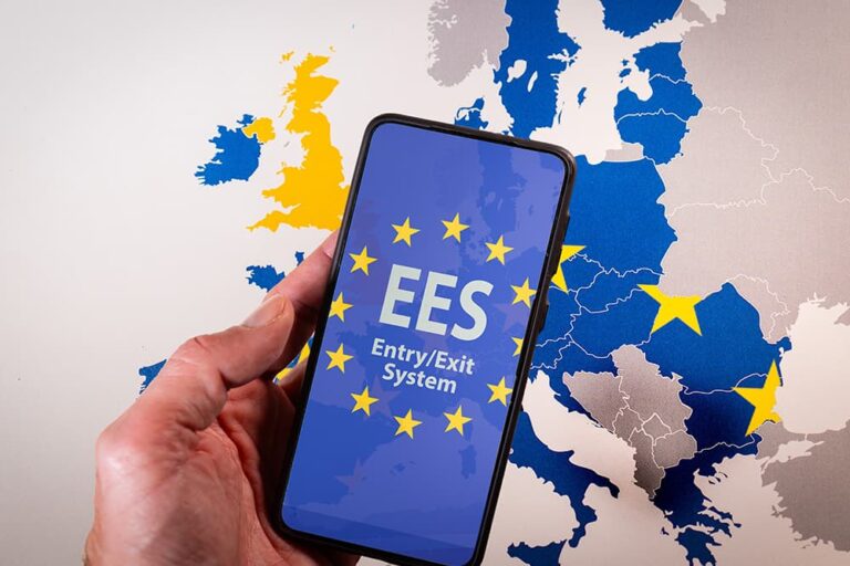 ヨーロッパ地図を背景に、EES（欧州出入国システム）の画面が表示されたスマートフォンを持つ様子。初回登録から出入国までの手続きの流れをイメージした画像