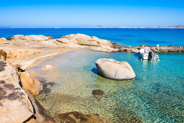 10月の秋でもゆっくりと過ごせる、ギリシャ・ナクソス島の透明度が高い美しいビーチと小舟の風景