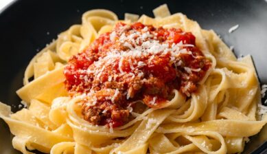 イタリア旅行で味わいたい有名な食べ物の代表例として紹介する、肉の旨みが詰まったラグーソースと粉チーズがたっぷりかかったボローニャ発祥のタリアテッレ