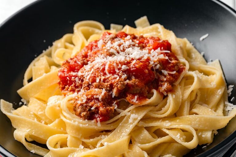 皿に盛られた平打ちパスタに、肉の旨みが詰まったラグーソースと粉チーズがたっぷりとかかる、イタリア・ボローニャ発祥の伝統料理タリアテッレ・アル・ラグー
