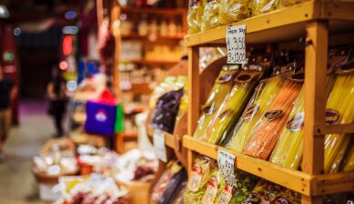 ローマのお土産（食品やお菓子、雑貨）を買う場所としておすすめの、色鮮やかなパスタが木の棚にずらりと並ぶスーパーマーケットの風景