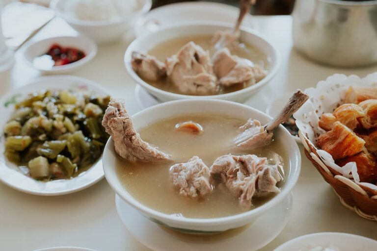 熱々のスープに大きな骨付き肉が入ったシンガポール名物「バクテー（肉骨茶）」。初めての海外旅行でも多国籍な食文化を安心して満喫できる、ローカルグルメの風景