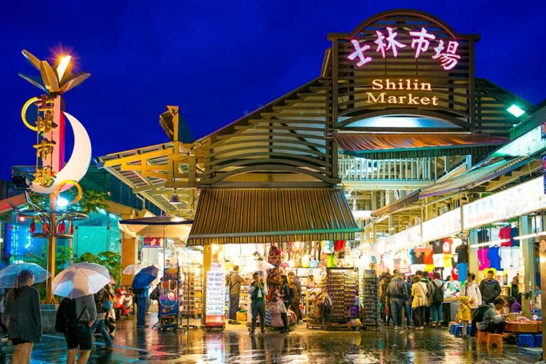 色鮮やかなネオン看板が輝く台北・士林夜市の入り口。初めての海外旅行でも安心して食べ歩きや街歩きを楽しめる、活気あふれる夜の風景