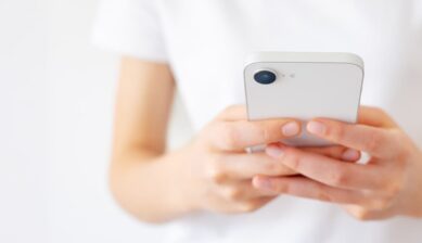 Wi-Fi環境下でノートPCの傍らiPhoneを操作し、SIMカードなしでできる機能や制限範囲を確認している様子