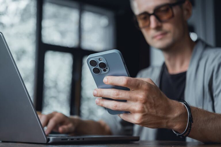 Wi-Fi環境下でノートPCの傍らiPhoneを操作し、SIMカードなしでできる機能や制限範囲を確認している様子