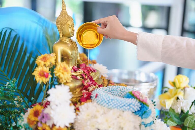 タイの水掛け祭り「ソンクラーン」で、花で飾られた仏像に清めの水をかける伝統的な儀式の様子