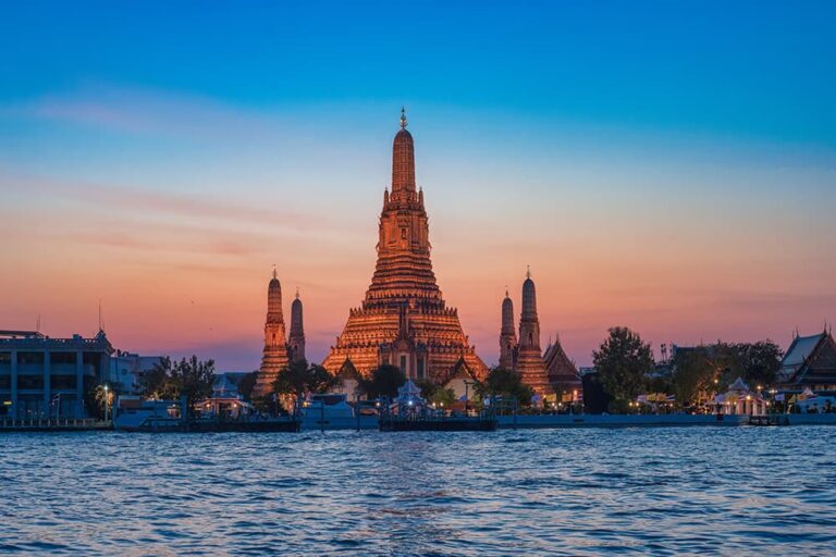 乾季の美しい夕焼け空を背景にライトアップされた、バンコクの寺院「ワット・アルン」の風景