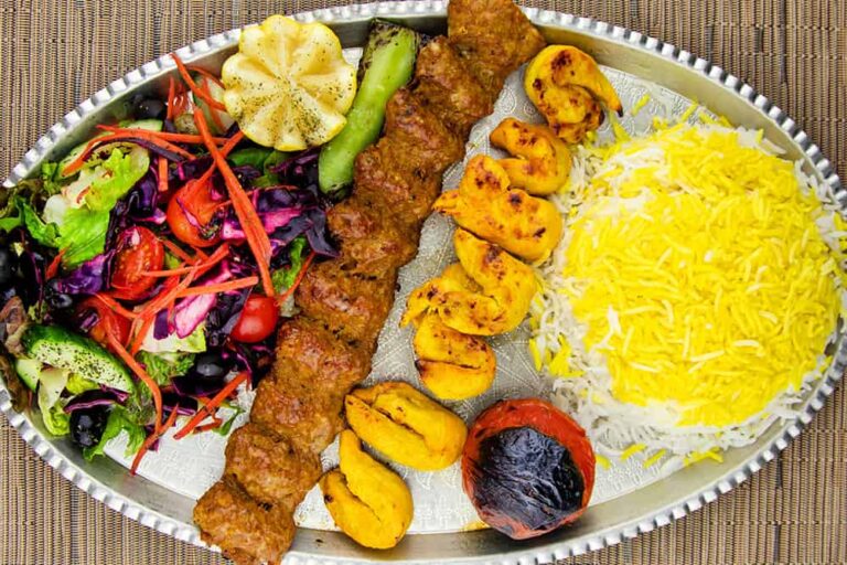ケバブやチキンティッカなど、ドバイで楽しめる香ばしい肉料理とライスやサラダの盛り合わせプレート