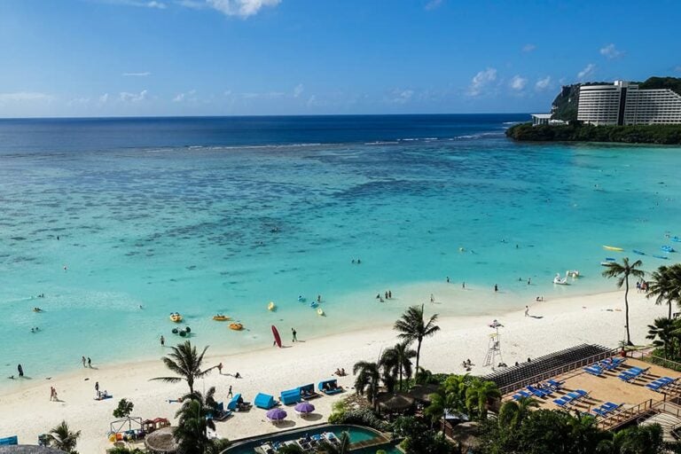 日本からの移動負担が少ないグアムの美しいリゾートビーチ。透き通る青い海と白い砂浜が広がり、新婚旅行でのんびり滞在を楽しむのに最適な風景