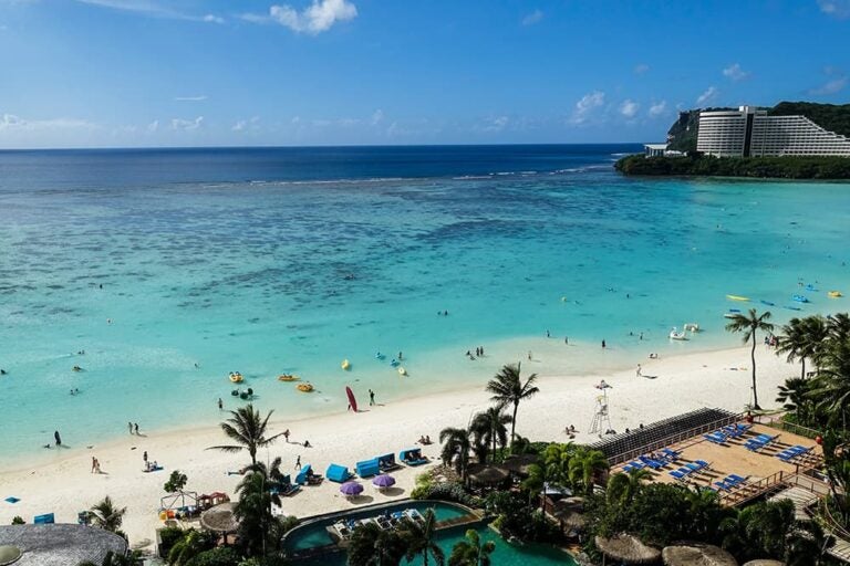 透き通るエメラルドグリーンの海と白い砂浜が広がる、日本から近い南の島・グアムのリゾートビーチの風景