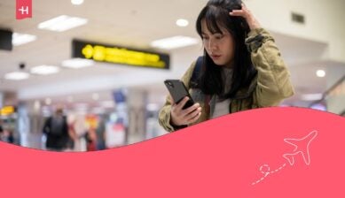 صورة مميزة لمراجعة Jetpac eSIM: تظهر شابة آسيوية مسافرة بمفردها، تبدو مرتبكة، وهي تقرأ معلومات رحلتها على هاتفها بوجه جاد ومتشكك، مما يعكس حاجتها لاتصال موثوق بالإنترنت