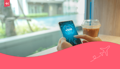 رجل يمسك بهاتف ذكي تظهر عليه كلمة "eSIM" أثناء جلوسه في مقهى، في إشارة إلى مراجعة شريحة Nomad eSIM.