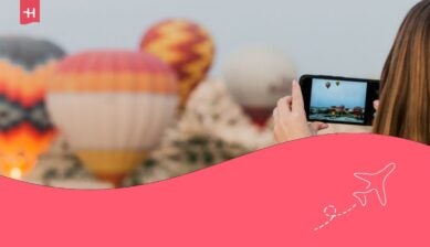 فتاة تلتقط صوراً لمناطيد الهواء الساخن باستخدام الهاتف.