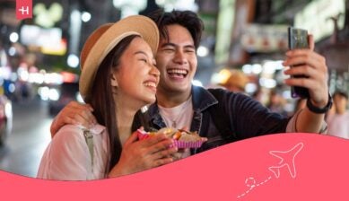 سائحان يستخدمان الهاتف أثناء التجول في تايلاند