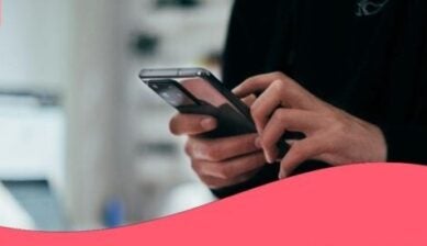 رجل يمسك هاتفاً ذكياً لاستخدام خدمة معرفة الجهاز من رقم IMEI.