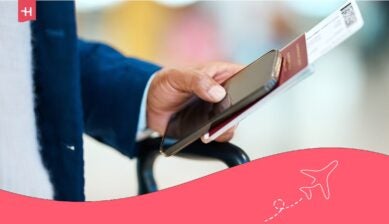 رجل يحمل هاتفاً ذكياً وجواز سفر في المطار استعداداً للسفر إلى الولايات المتحدة