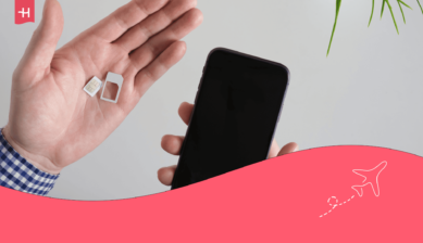 يد رجل تحمل شريحة SIM لهاتف ذكي؛ صورة بارزة لمقال حول كيفية استخراج شريحة إلكترونية (حذفها).