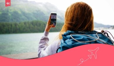 مسافرة تلتقط صورة بهاتفها في الخارج مع إمكانية الوصول إلى انترنت دولي أثناء السفر