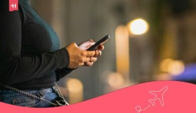 شخص يستخدم هاتفه في الخارج ليلاً للتحقق من استهلاك البيانات ومعرفة كم جيجا تكفي ليوم واحد