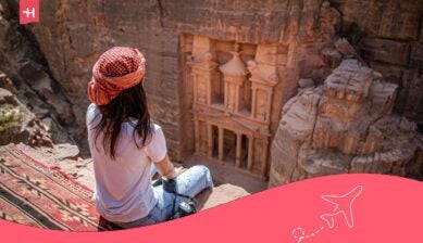 مسافرة تجلس أمام خزنة البتراء في الأردن وتبحث عن أفضل شريحة نت في الأردن لرحلتها